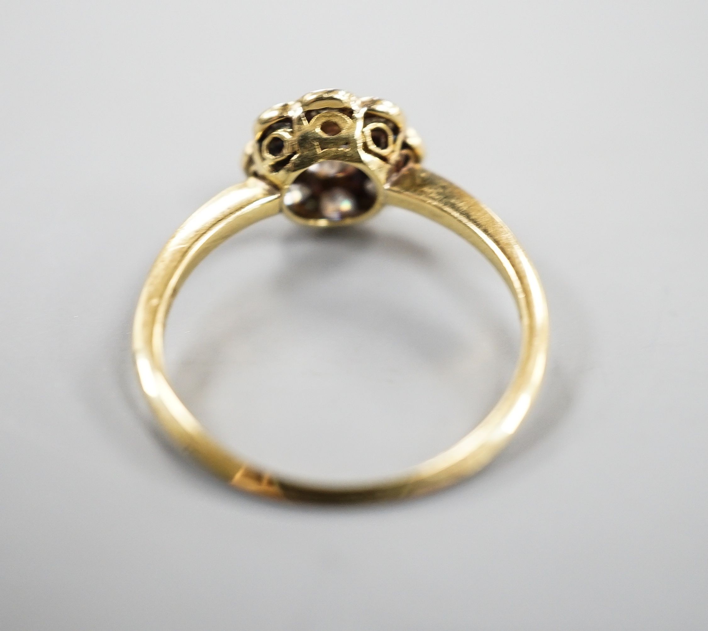 An 18ct, Pt and diamond set flower head cluster ring, size N, gross weight 2.4 grams.